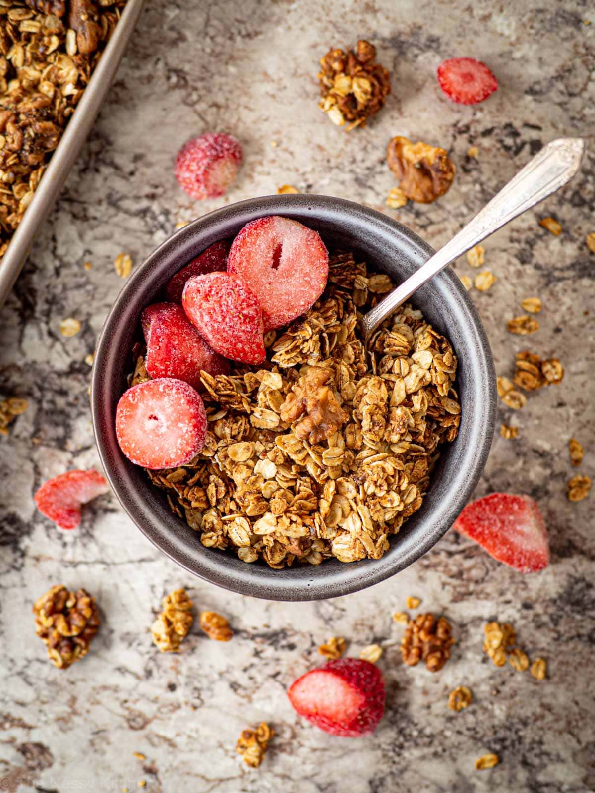 Bowl of granola topped with strawberries.