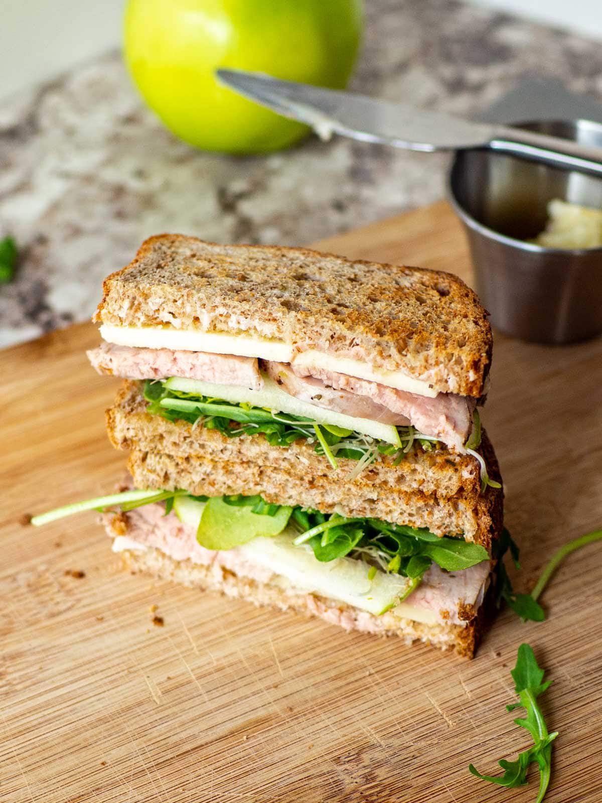 Pork tenderloin sandwich sliced in half and stacked on top of each other.