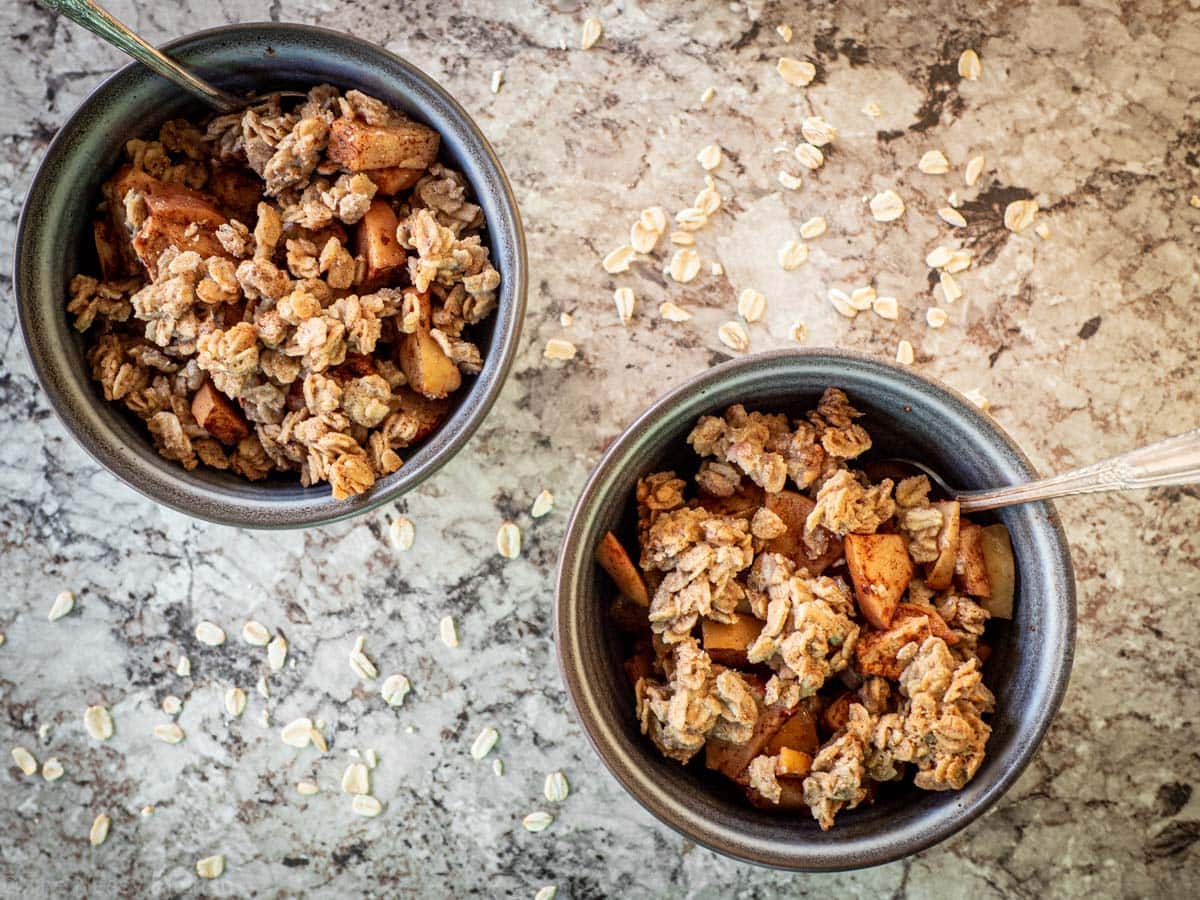 Top view of two grey bowls filled with apple crisp.