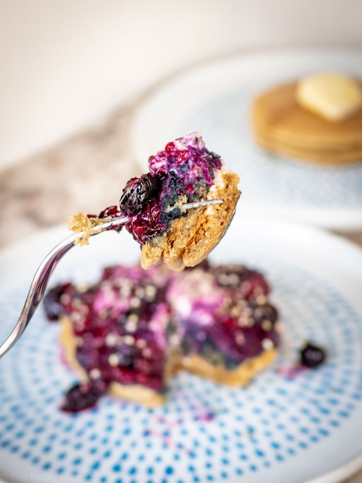 A bit of pancakes on a fork with berries,