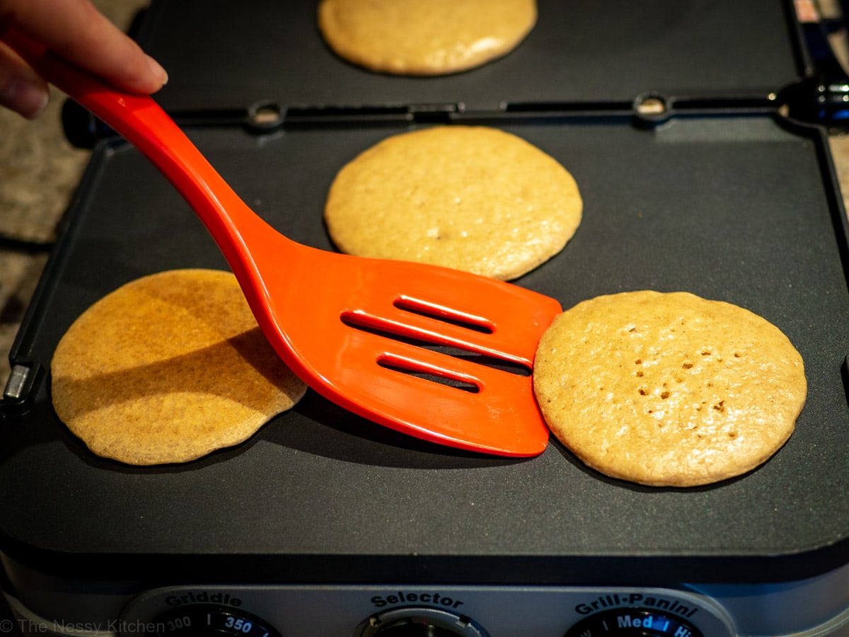 Pancakes cooking on an electric griddle.