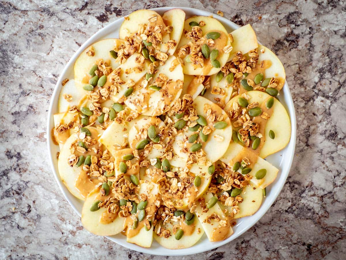 Apples topped with granola and pepitas.