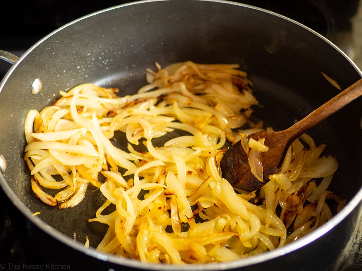 Onions being caramelized in a skillet.