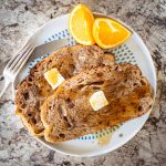 Plate of French toast topped with butter and syrup.