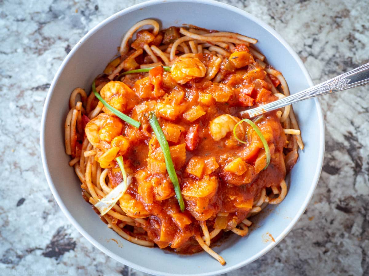 Top view of a bowl of pasta with a tomato sauce and shrimp.