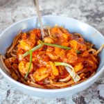 Bowl of spaghetti topped with a tomato shrimp sauce.