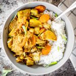 Grey bowl filled with Jamaican chicken curry over rice.