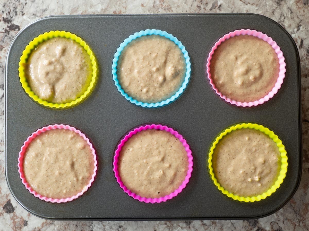 Muffin batter divided into a tin with muffin liners.