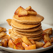 Stack of pancakes topped with sautéed apples.