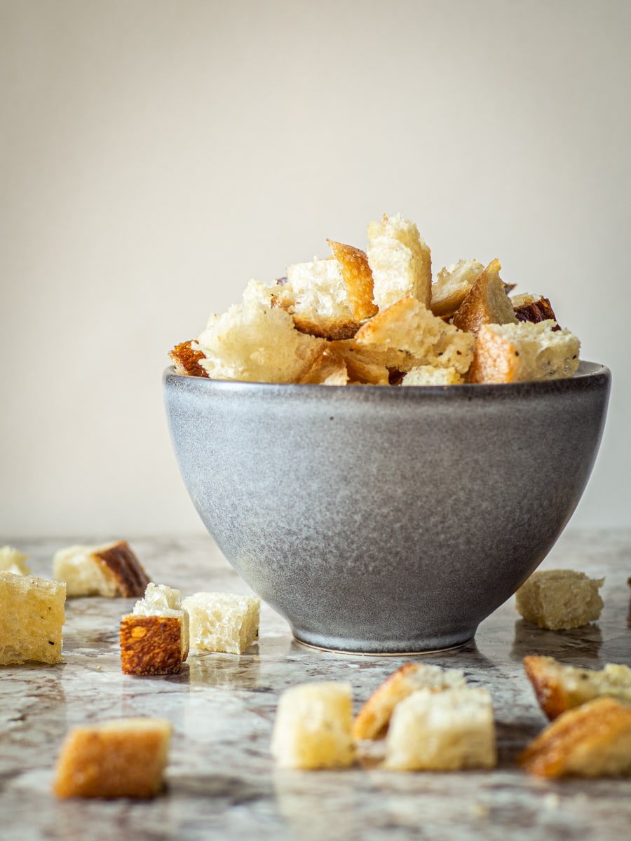 Bowl of sourdough croutons sitting on a counter.