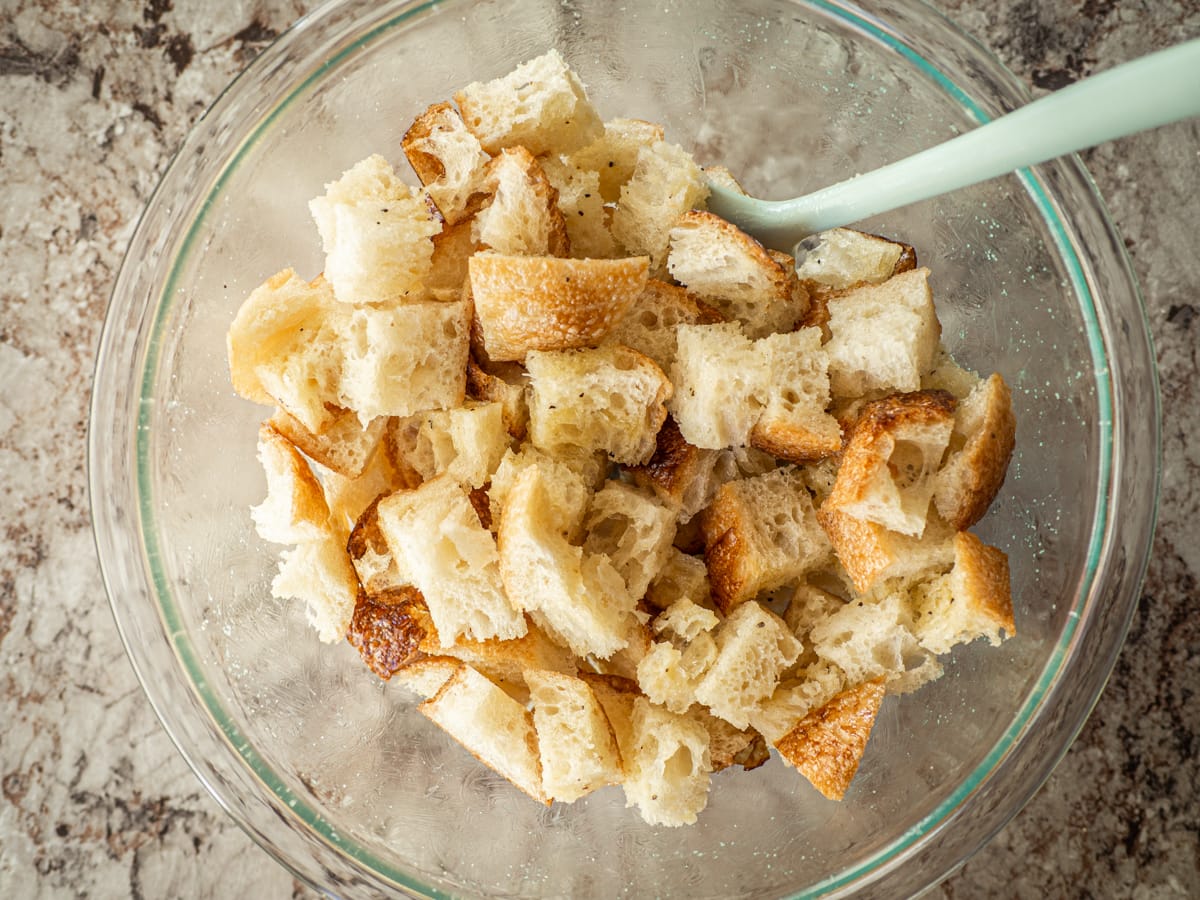 Bread in a bowl mixed with butter and seasonings.