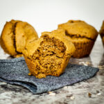 Pumpkin muffin with a bite taken out.