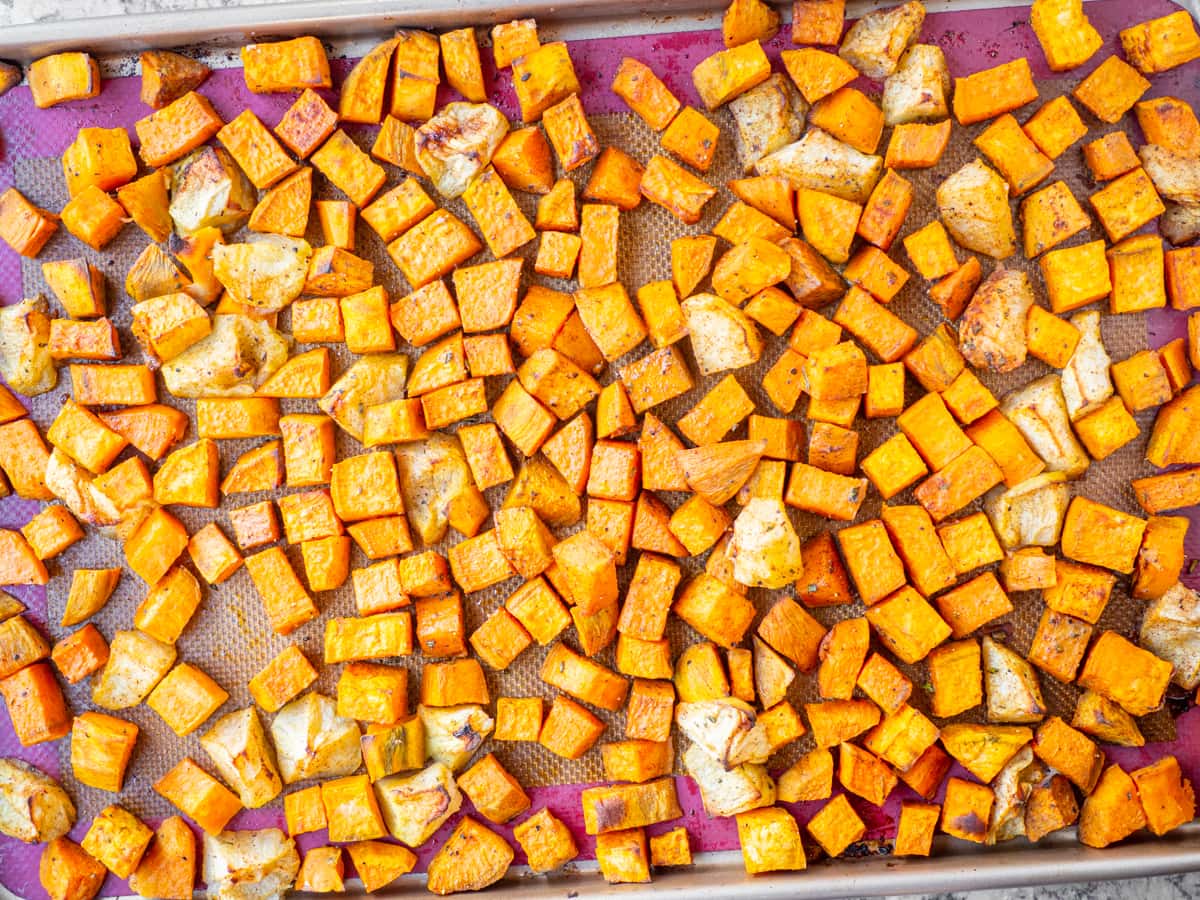 Baked apples and sweet potatoes on a sheet pan.