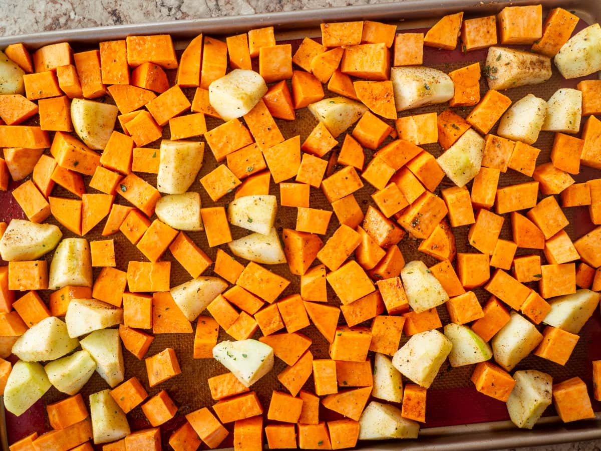 Apples and sweet potatoes mixed with oil and seasonings.