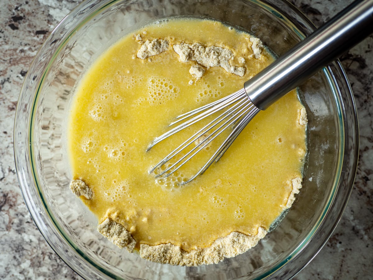 Wet ingredients poured into the center of the bowl of dry ingredients.