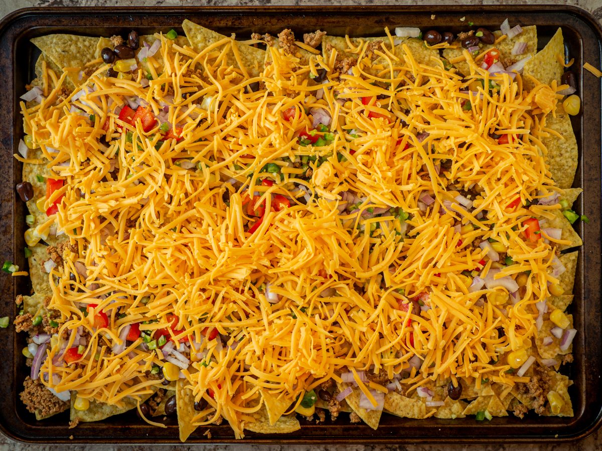 Cheese spread out over tortilla chips.