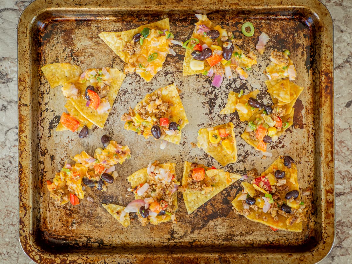 Pan with leftover nachos spread out to reheat.