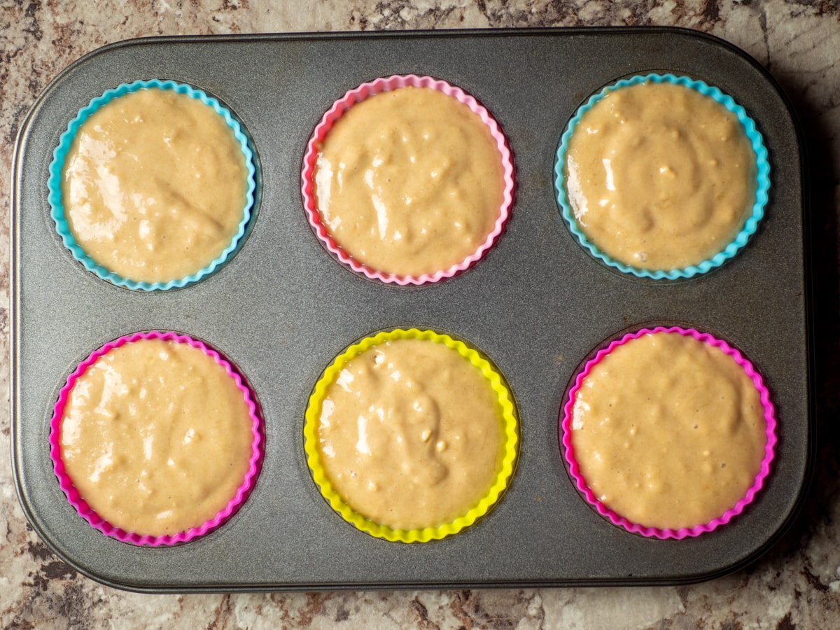 Muffin batter divided out into a muffin tin.