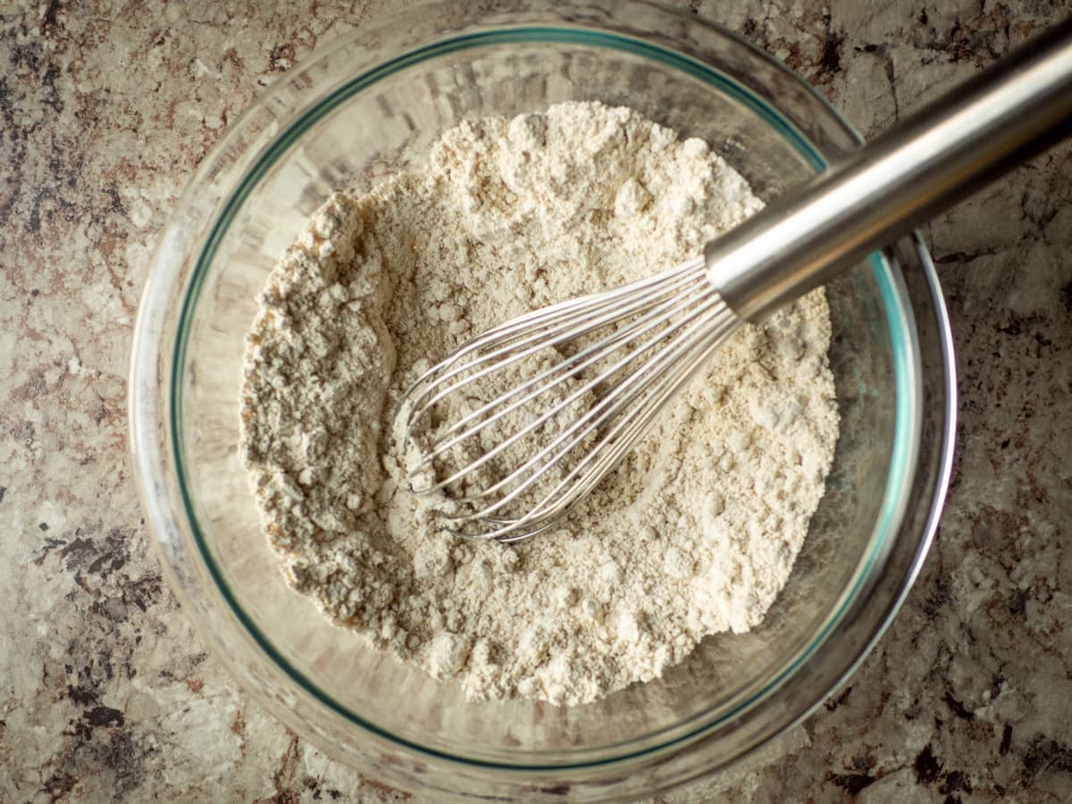 Oat flour whisked in a bowl with baking soda and powder.