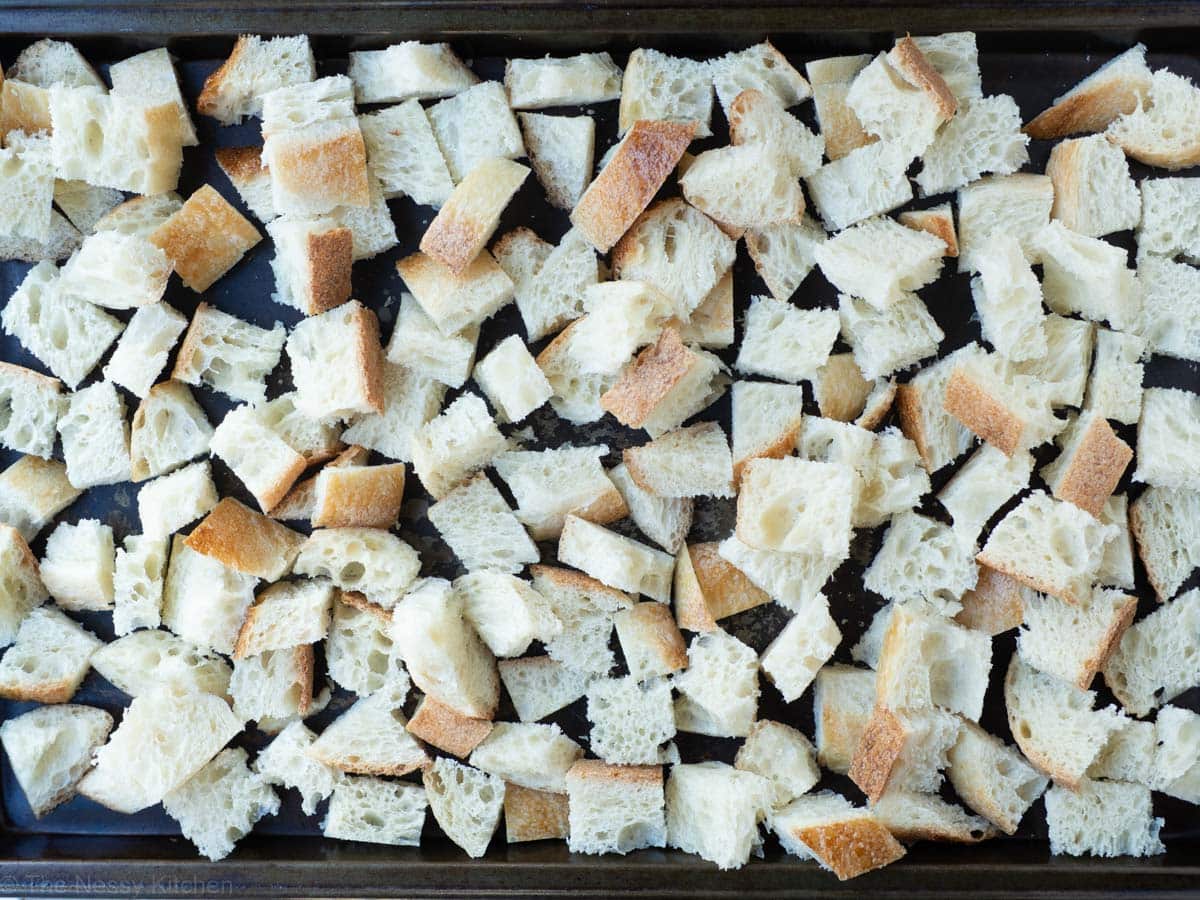 Bread cubes drying out on a sheet pan.