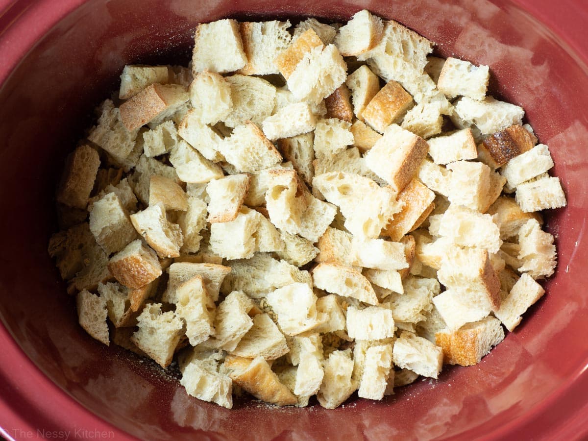 Bread cubes added to the bottom of a slow cooker.