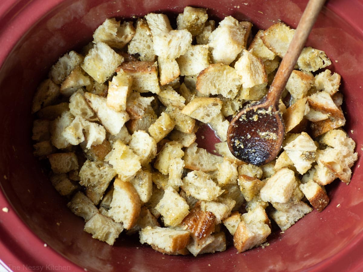 Water added to the slow cooker with bread cubes.