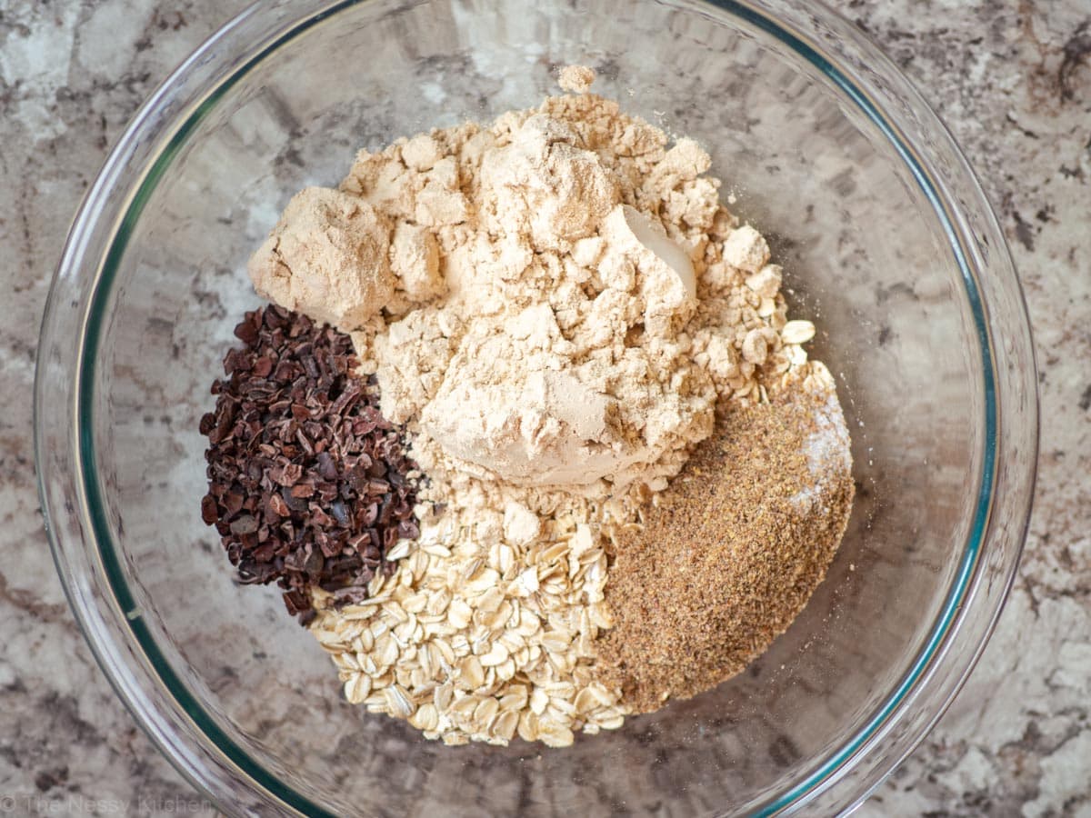 Oats,  protein powder, cocoa nibs, flax, salt and espresso powder in a bowl.
