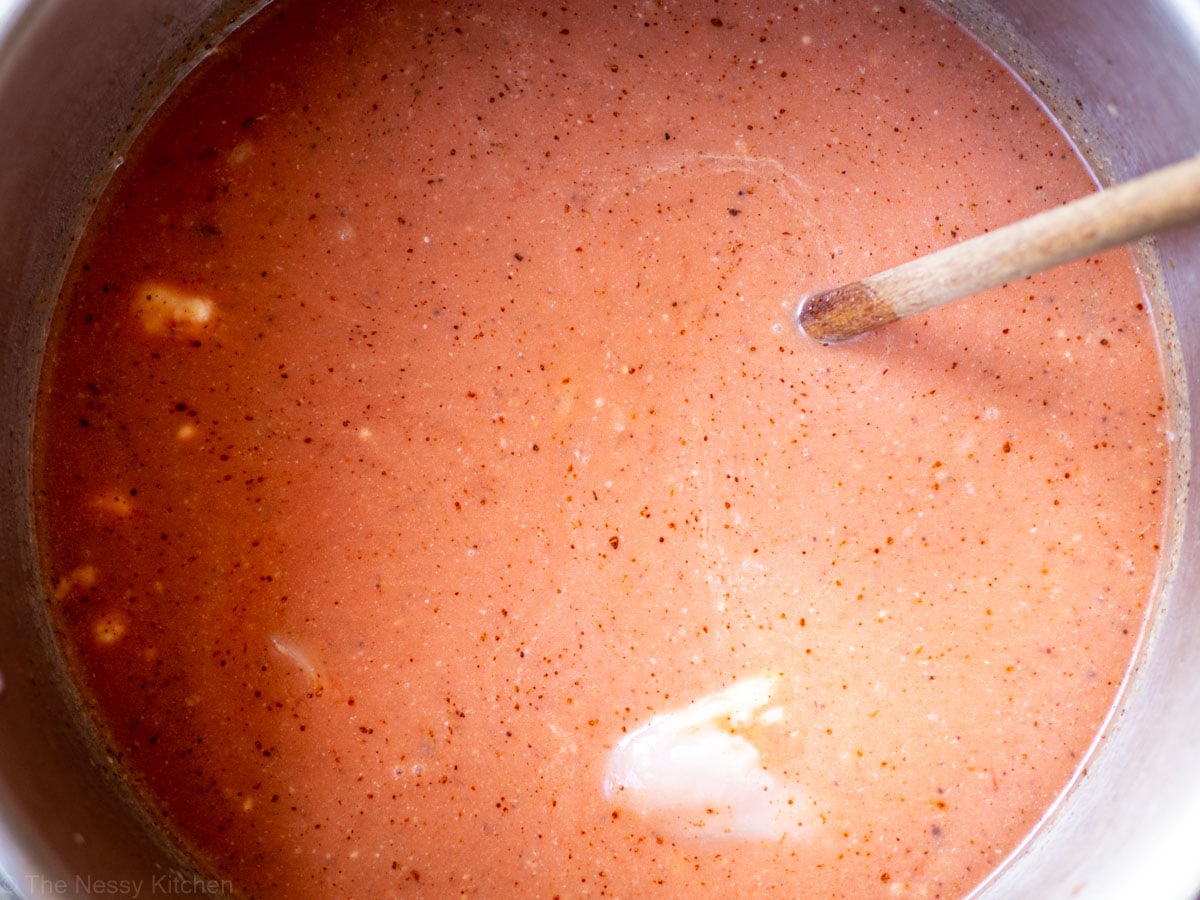 Tomatoes, coconut milk and chicken added to the pot.