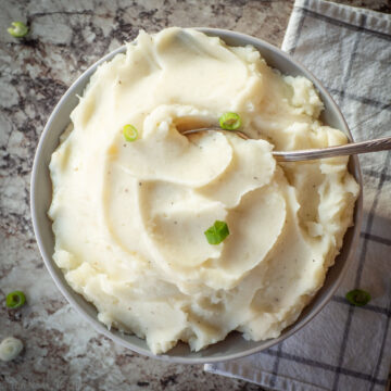 Bowl of mashed potatoes topped with chives.