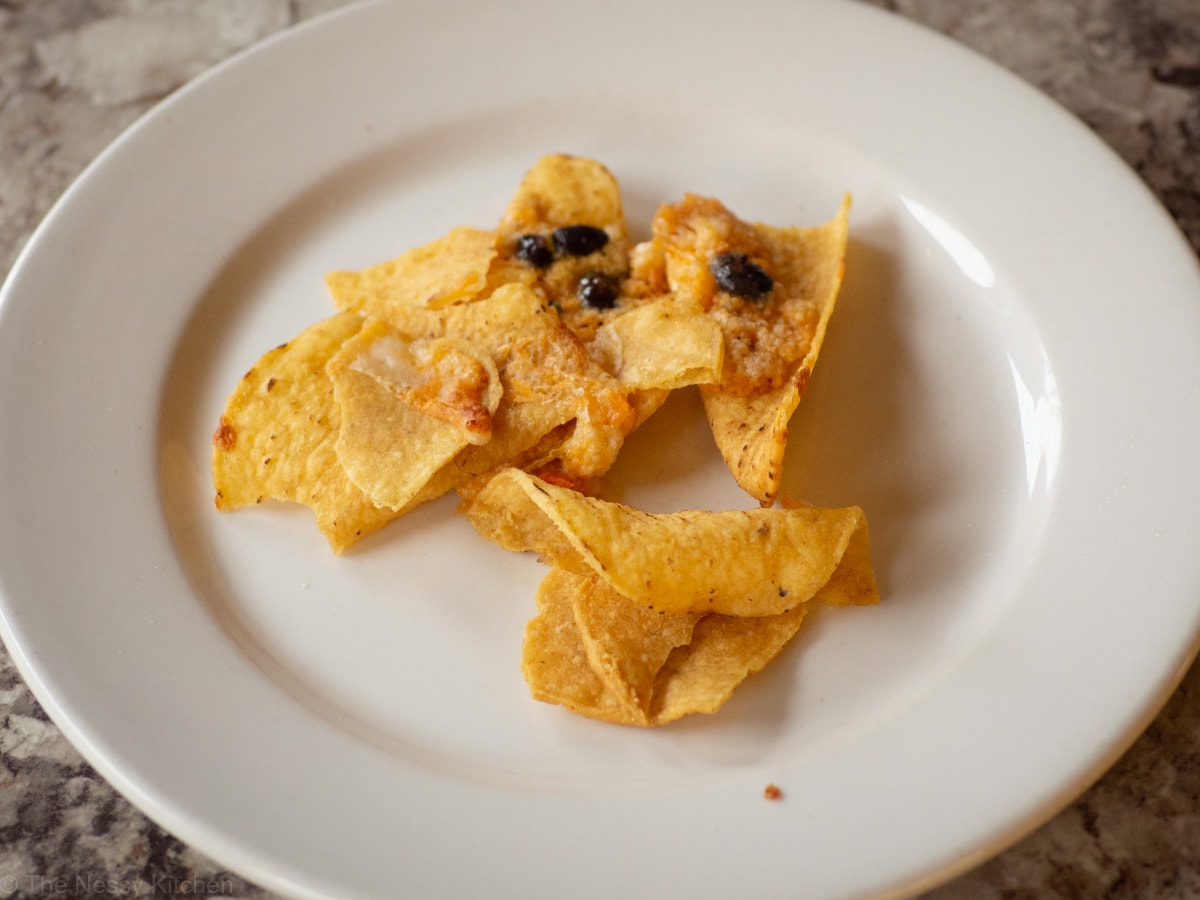 Nachos on a plate after being warmed in the microwave.
