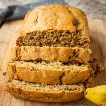 Banana bread sliced on a cutting board.