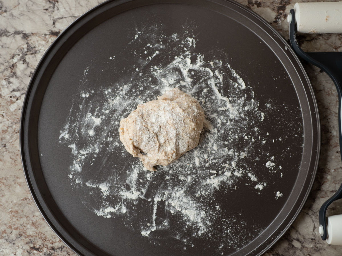 Floured pizza pan with dough.