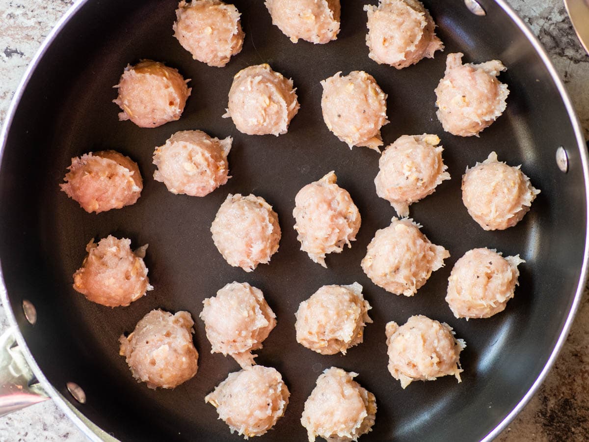 Meatballs portioned out into a skillet.