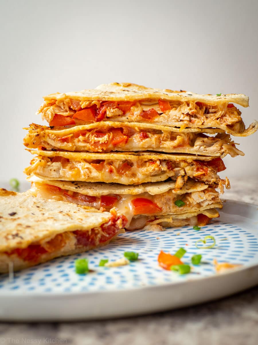 Corn tortilla quesadillas stacked on a plate.