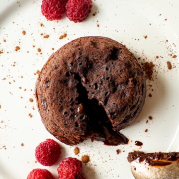 Lava cake on a plate with chocolate spilling out.