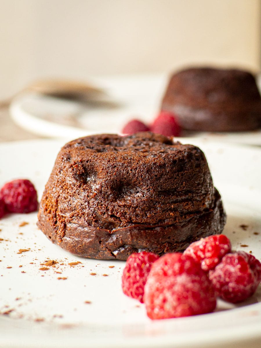 Lava cake on a plate with raspberries.