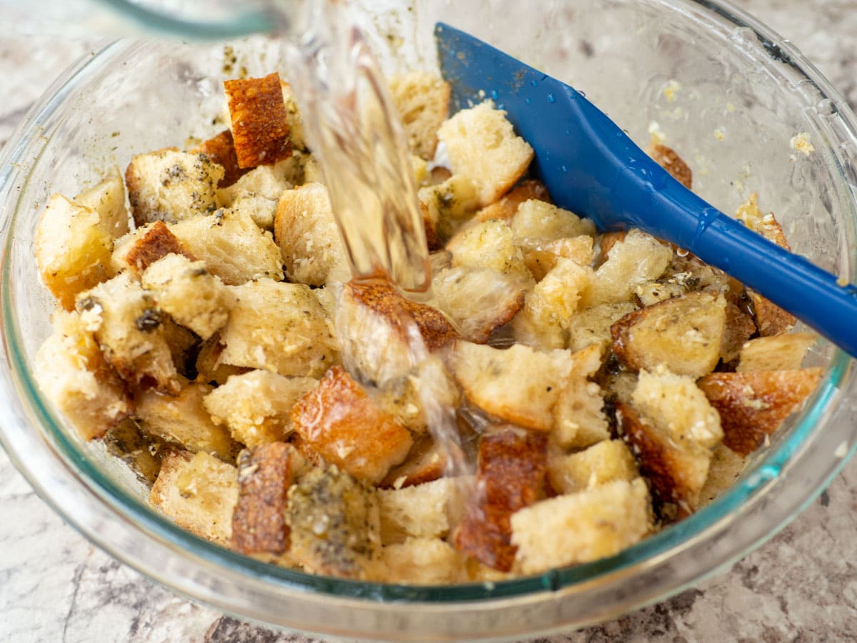 Bowl of bread cubes mixed with butter and seasonings.