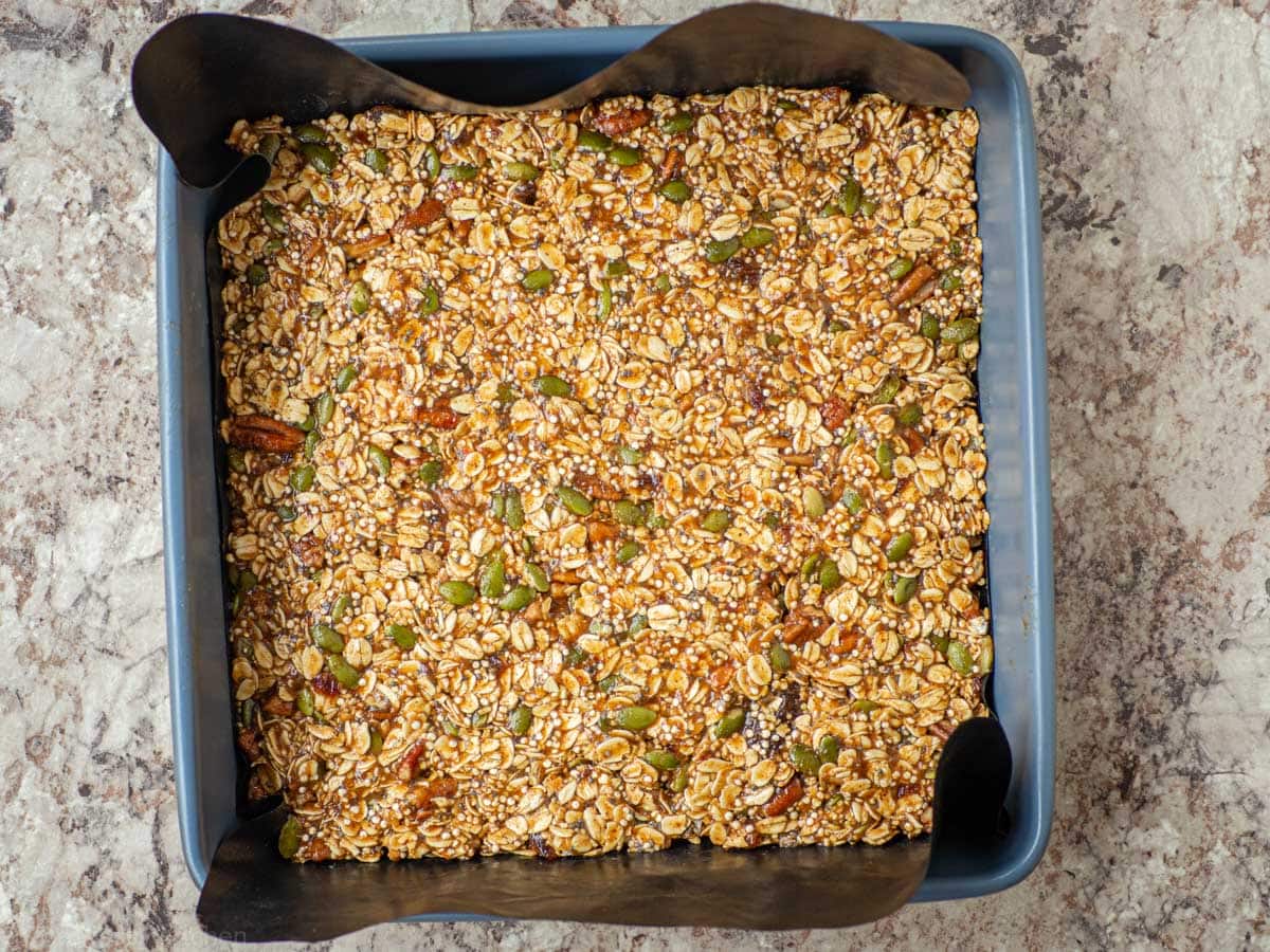 Quinoa granola batter pressed into a baking pan.