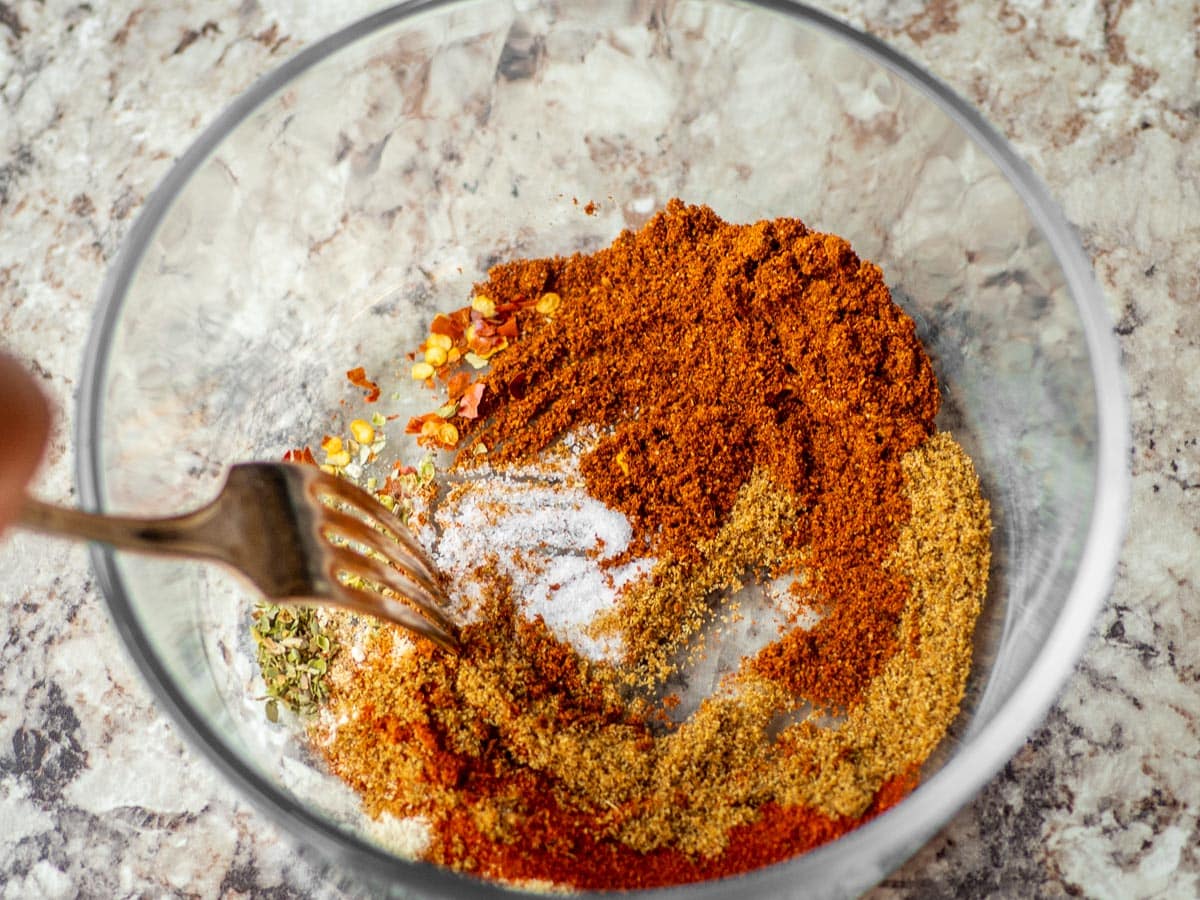 Ingredients being stirred together in a bowl using a fork.