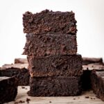 Stack of brownies made with oat flour on a cutting board.