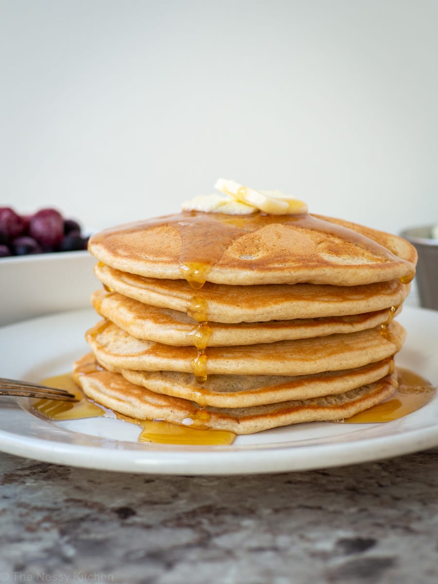 Stack of pancakes with butter and maple syrup.