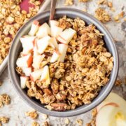 Granola in a bowl topped with diced apples.