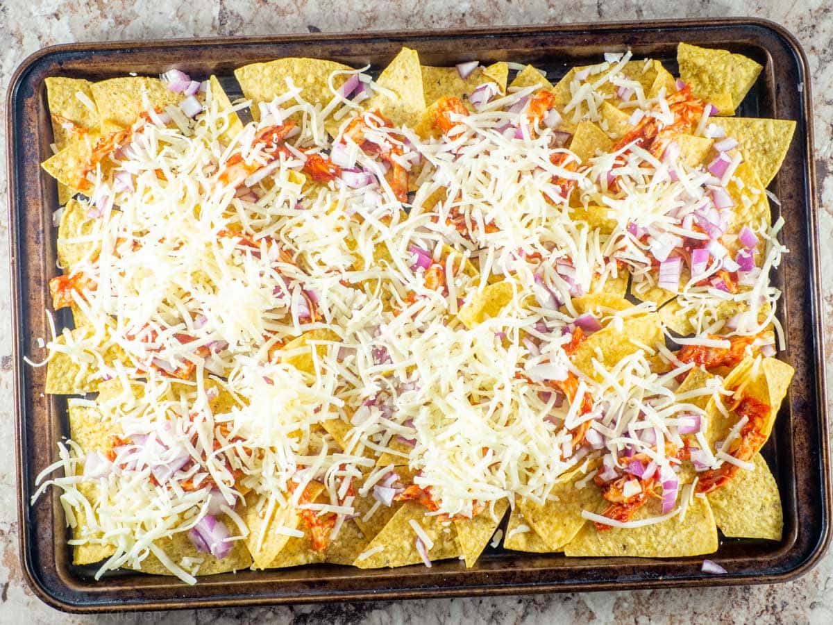 Cheese topping a layer of nacho chips.