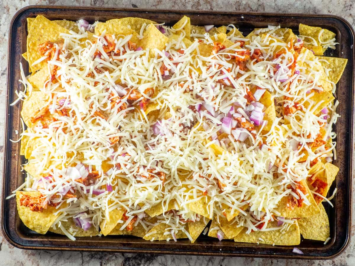 Second layer of nachos assembled on a sheet pan.
