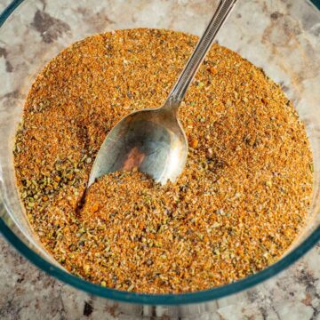 Spice blend in a bowl with a spoon.