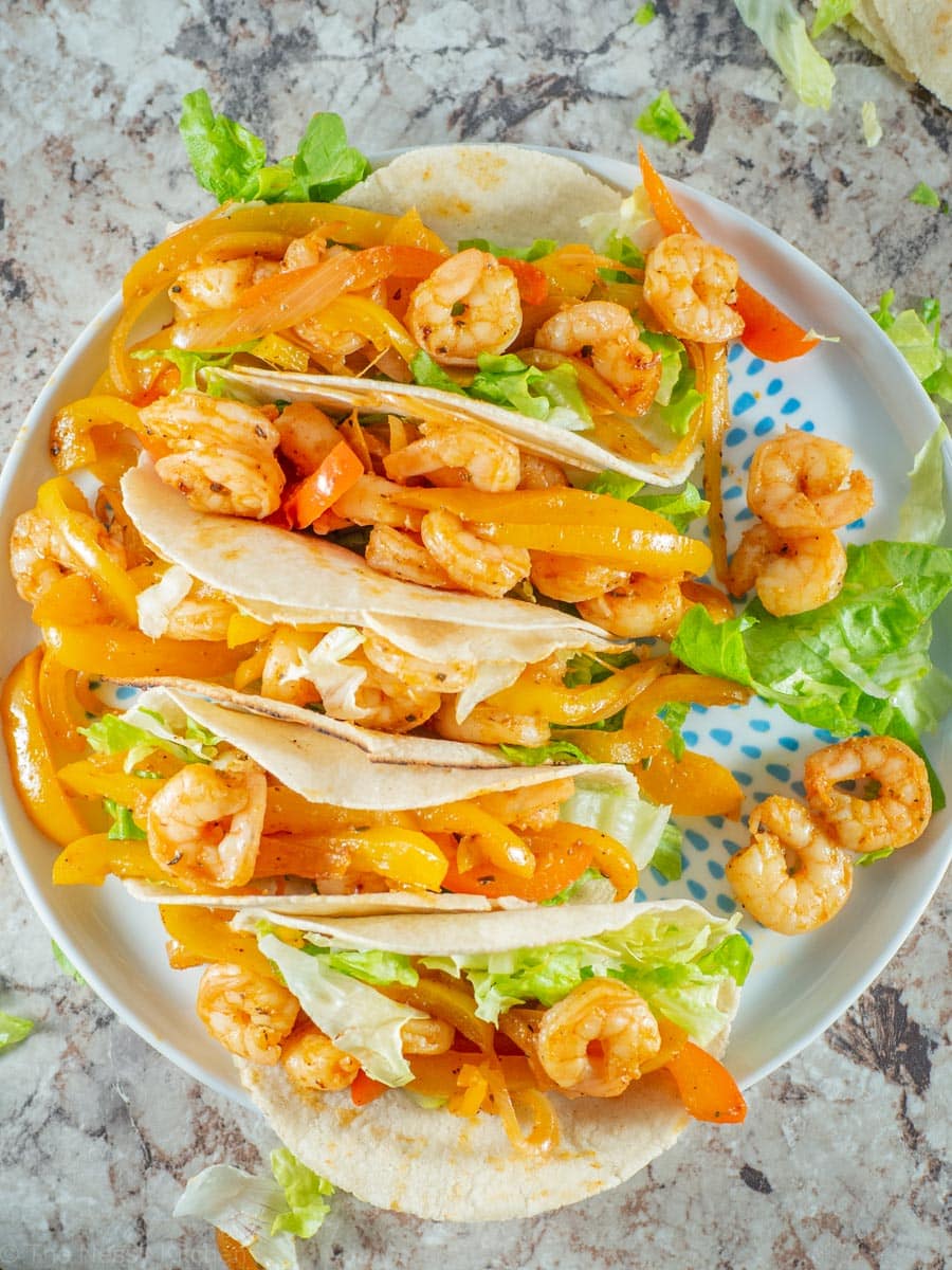 Tortillas topped with shrimp, lettuce and sautéed vegetables.