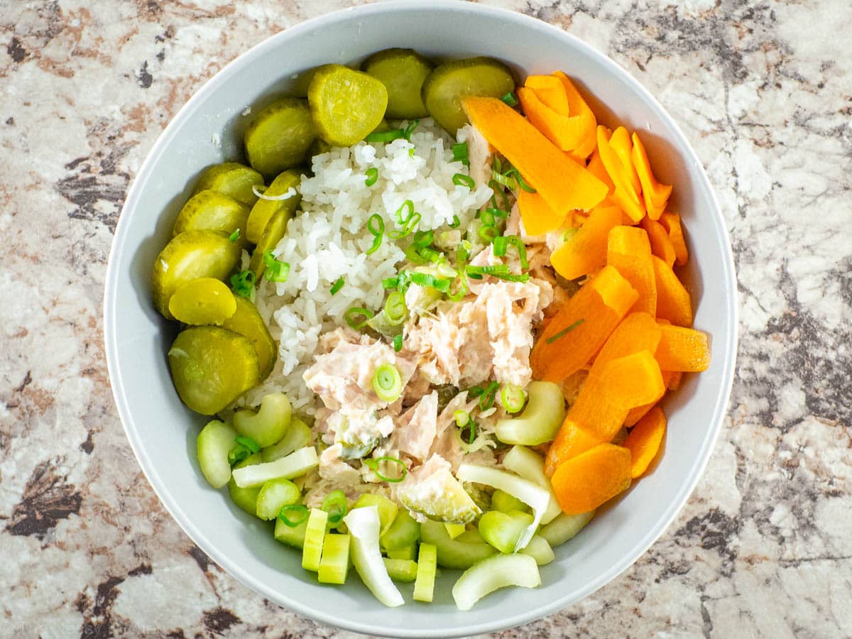 Vegetables added to garnish a bowl of rice and tuna.