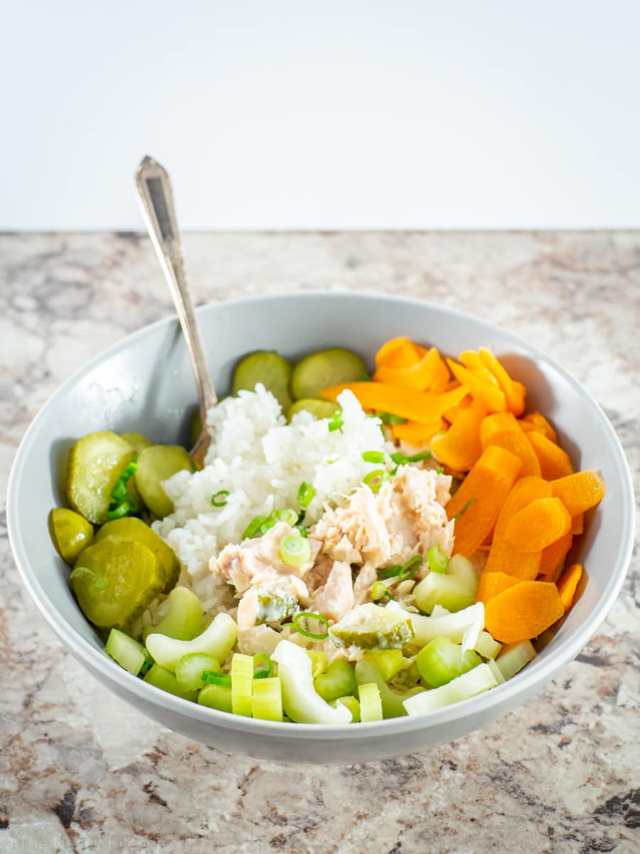 Canned tuna over rice in a bowl with vegetables.