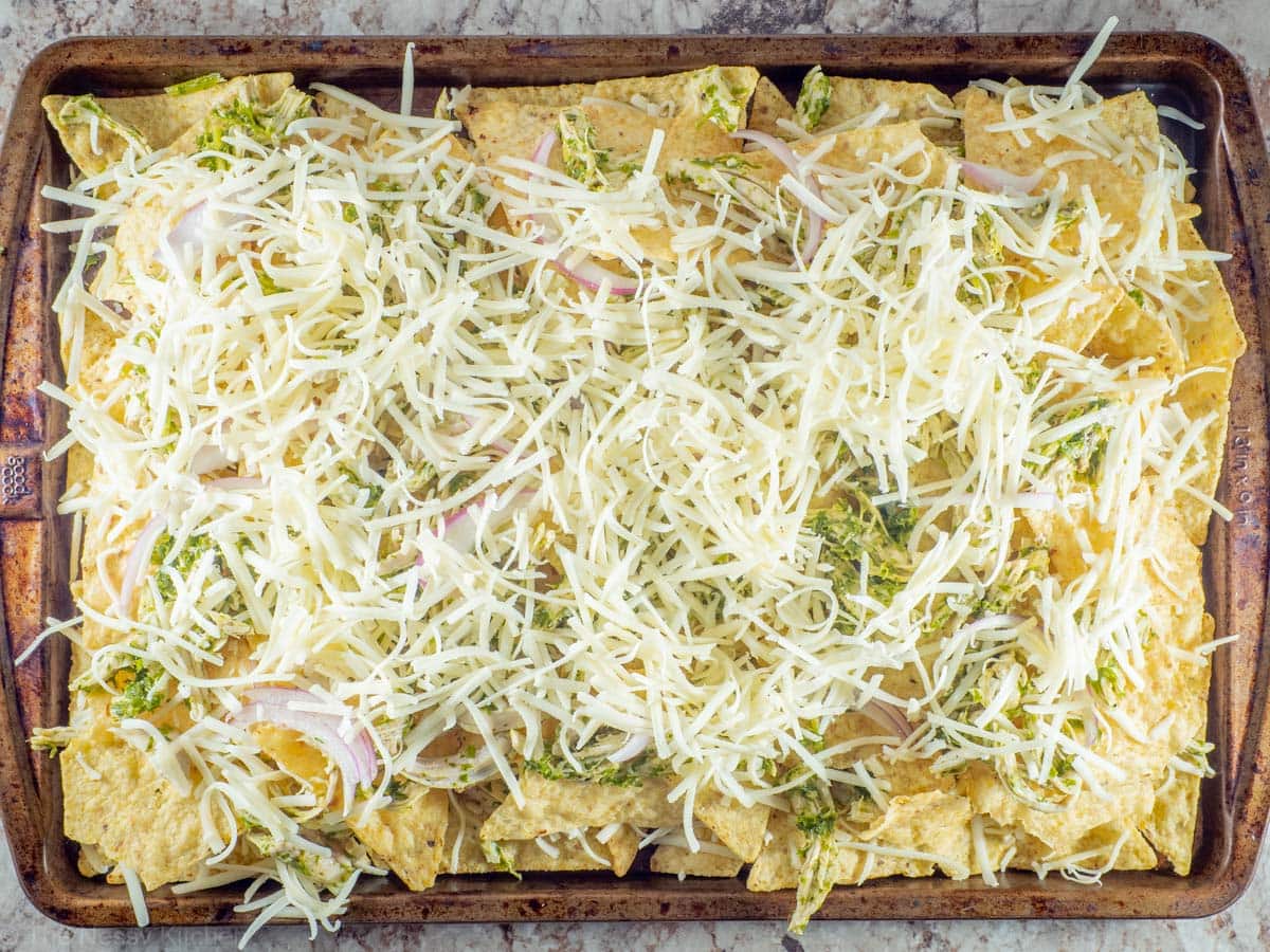 Second layer of nachos assembled on top of the first on a sheet pan.