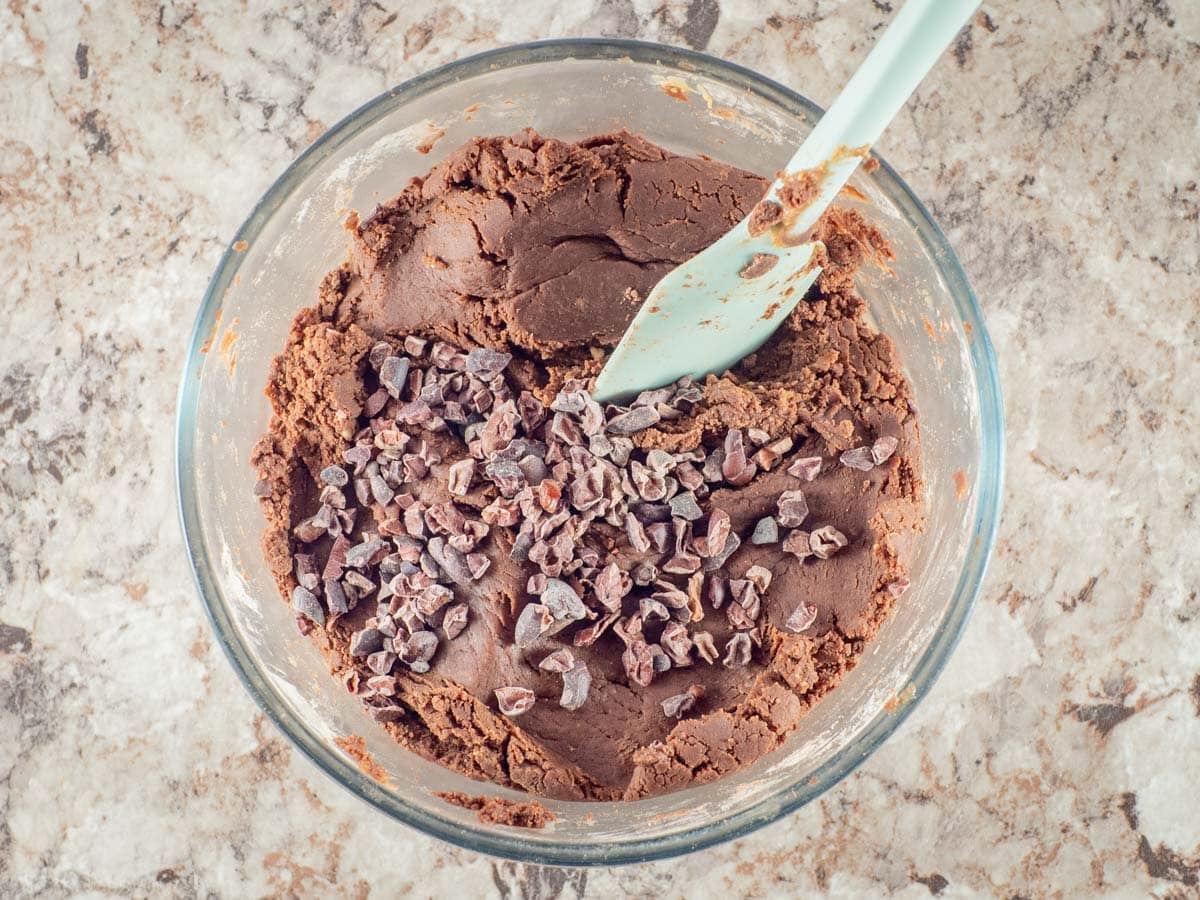 Cacao nibs added to mixture in a bowl.
